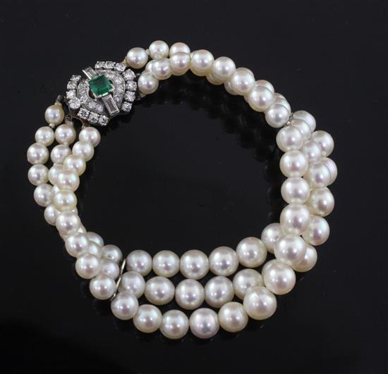 A French triple strand graduated cultured pearl bracelet with 18ct gold and platinum, emerald and diamond set clasp, 18.5cm.